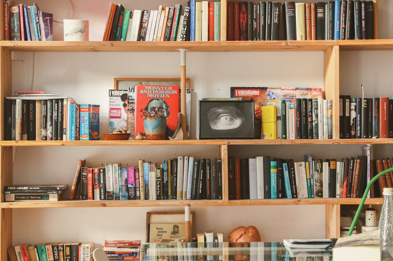 Wooden bookshelf filled with diverse books and decor in a cozy setting.